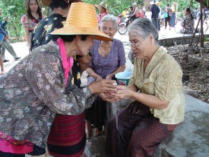 Songkran traditionell: kleine Mengen von Wasser werden älteren Familienmitgliedern über die Hände gegossen.